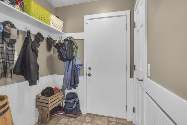 mudroom with stone finish floor and a wainscoted wall