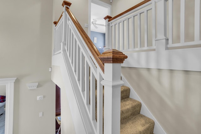 stairs with carpet flooring, a ceiling fan, and baseboards