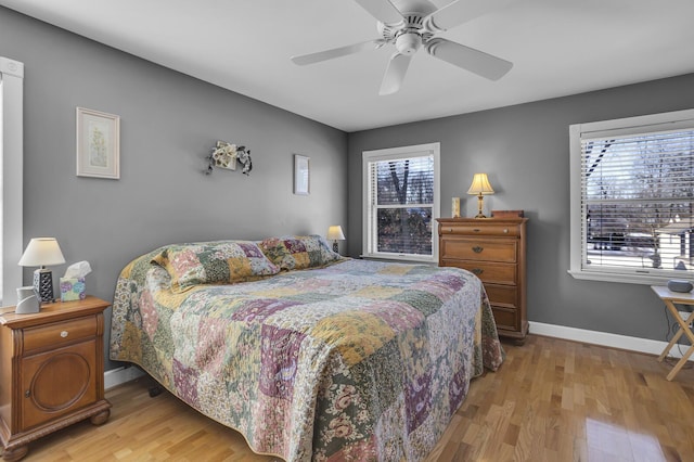 bedroom with ceiling fan, baseboards, and wood finished floors