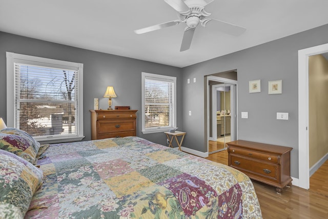 bedroom featuring ceiling fan, baseboards, and wood finished floors