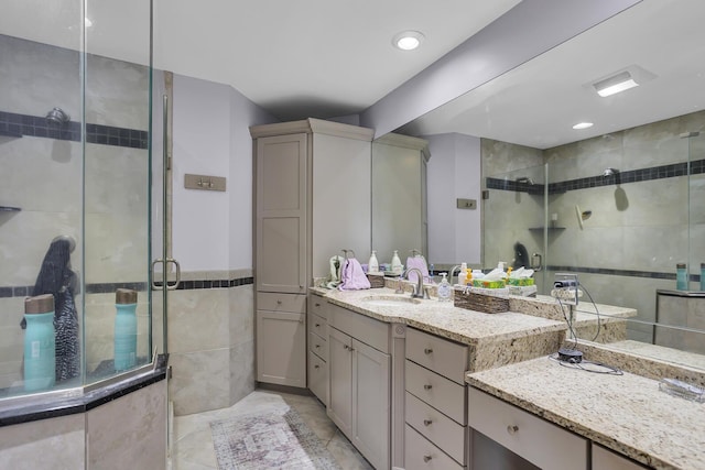 full bathroom featuring a stall shower, tile walls, vanity, and tile patterned floors