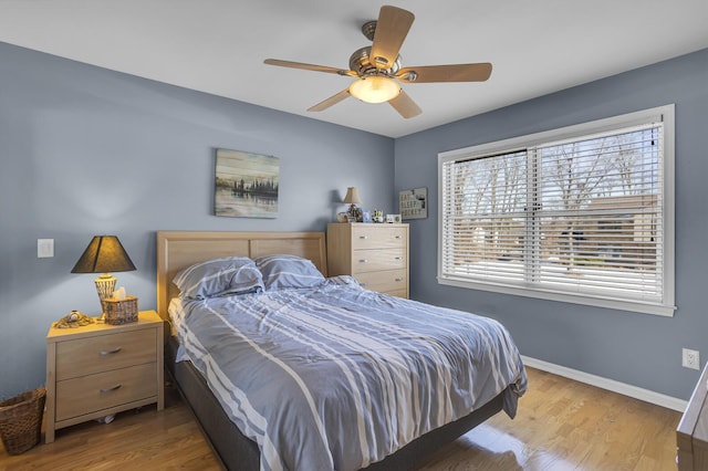 bedroom with a ceiling fan, baseboards, and wood finished floors