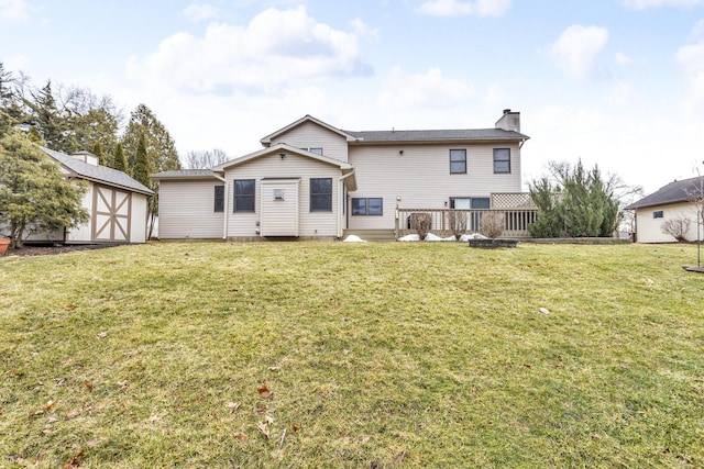 back of house featuring an outbuilding, a yard, a chimney, a storage unit, and a wooden deck