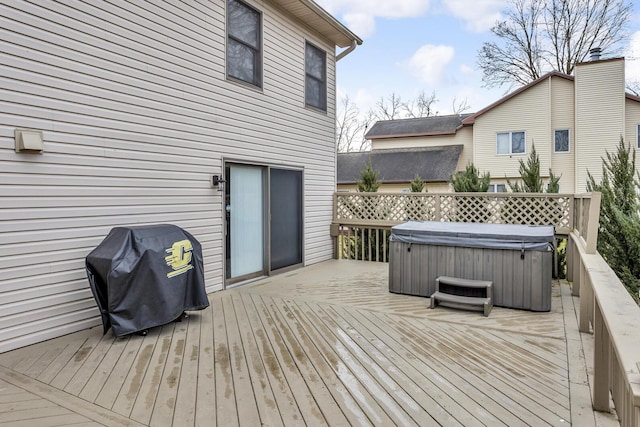 wooden terrace featuring a hot tub and area for grilling