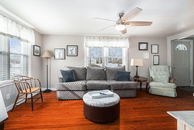 living room featuring baseboards, a ceiling fan, and wood finished floors