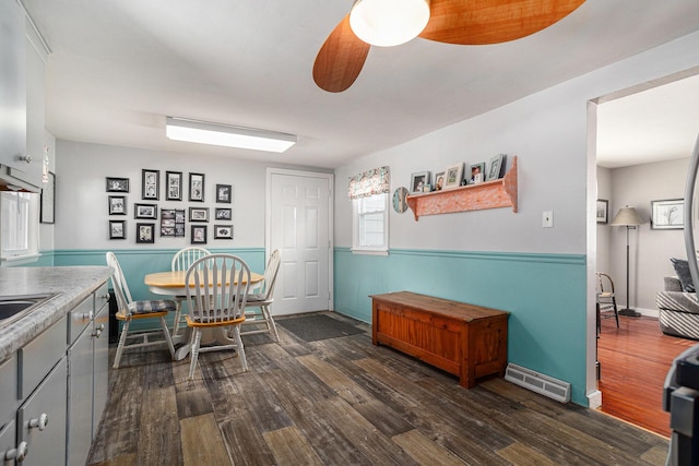 dining room featuring dark wood-style floors, visible vents, ceiling fan, and baseboards