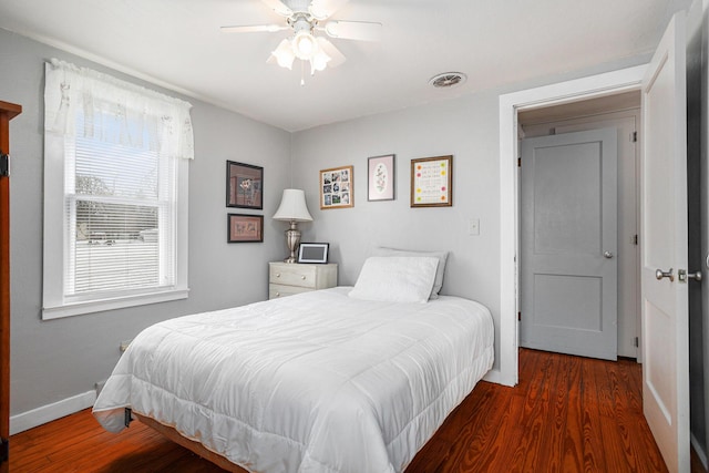 bedroom with visible vents, ceiling fan, baseboards, and wood finished floors