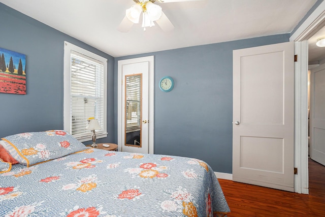 bedroom featuring ceiling fan, baseboards, and wood finished floors