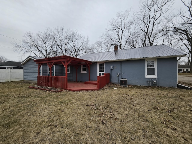 back of house featuring metal roof, central AC, fence, a lawn, and a wooden deck