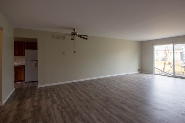 unfurnished living room featuring a ceiling fan, baseboards, and wood finished floors