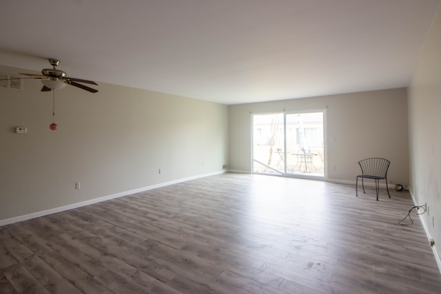 unfurnished room featuring ceiling fan, baseboards, and wood finished floors