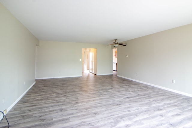 spare room with ceiling fan, baseboards, and wood finished floors