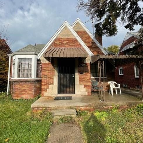 back of property with a patio and brick siding