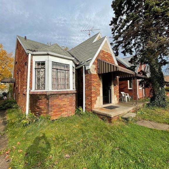 back of house with a patio area, a yard, and brick siding