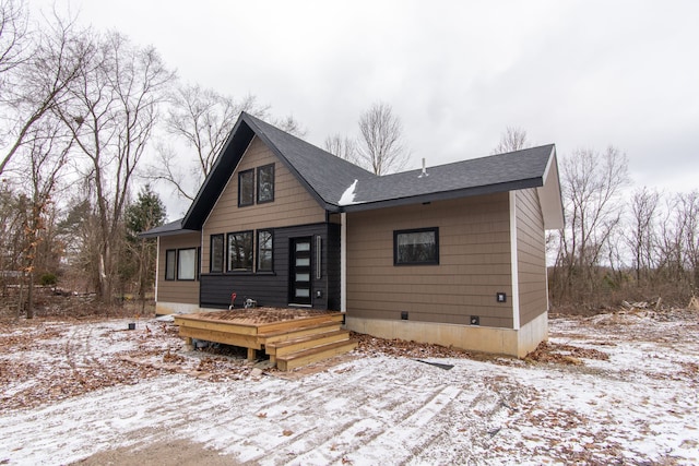 snow covered property featuring a shingled roof, crawl space, and a deck