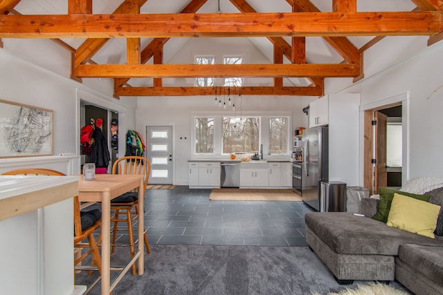 living room with dark tile patterned floors, beamed ceiling, and high vaulted ceiling