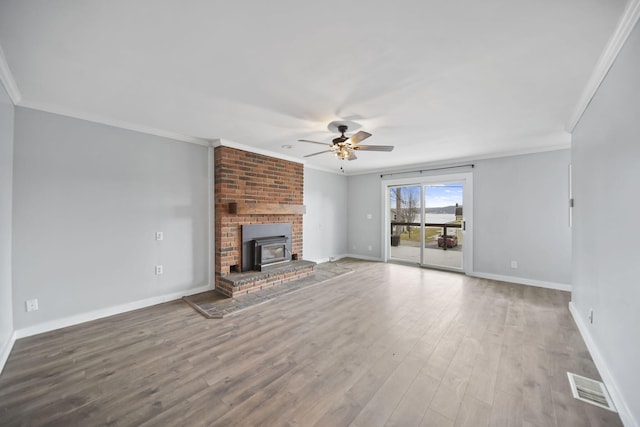 unfurnished living room featuring baseboards, visible vents, crown molding, and wood finished floors