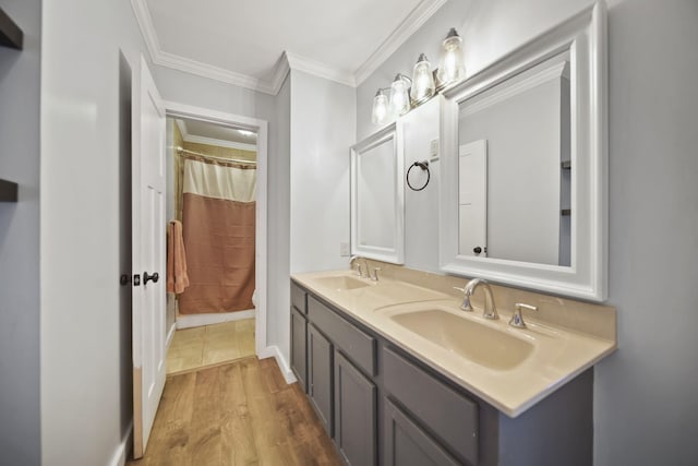 full bathroom featuring double vanity, crown molding, a sink, and wood finished floors