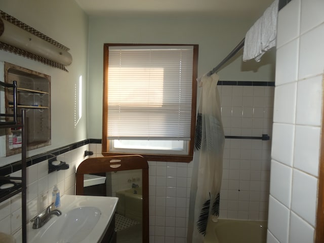 full bath with wainscoting, tile walls, and vanity