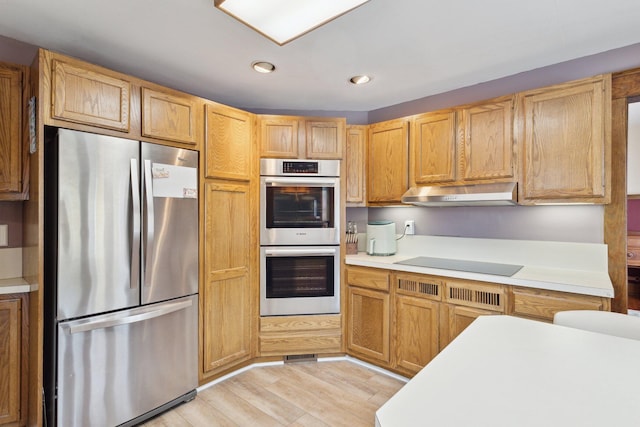 kitchen featuring stainless steel appliances, recessed lighting, light countertops, light wood-type flooring, and under cabinet range hood