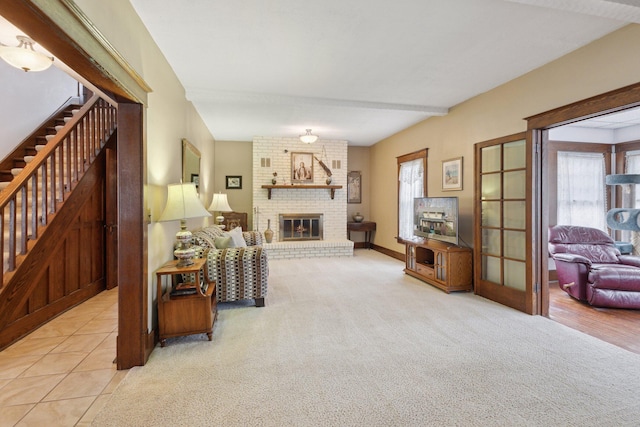 tiled living area featuring carpet floors, a brick fireplace, baseboards, and stairs