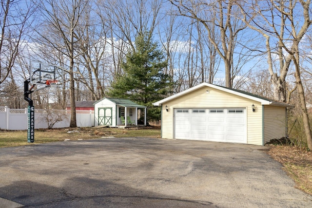 exterior space with an outbuilding, fence, and a detached garage