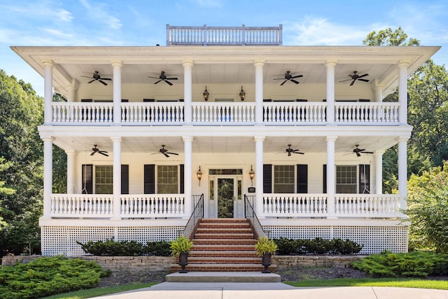 neoclassical home with covered porch, stairway, a balcony, and a ceiling fan