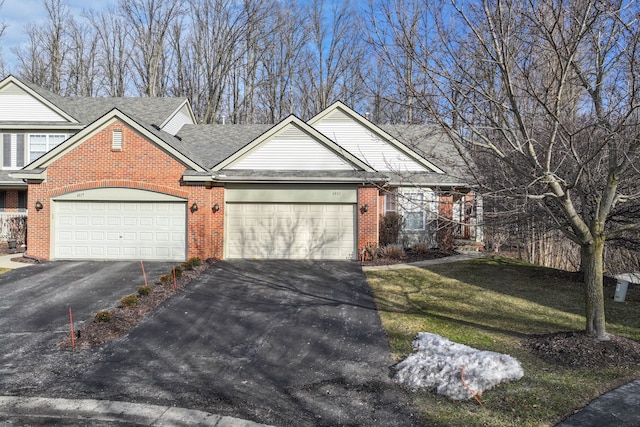 view of front facade featuring a garage, a front lawn, aphalt driveway, and brick siding