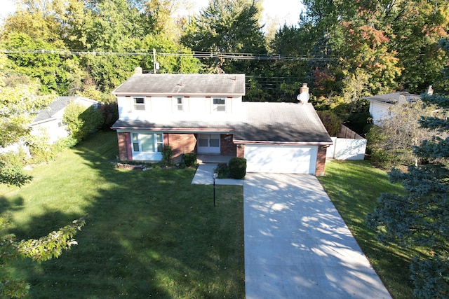 traditional home featuring a garage, driveway, a chimney, a front yard, and brick siding