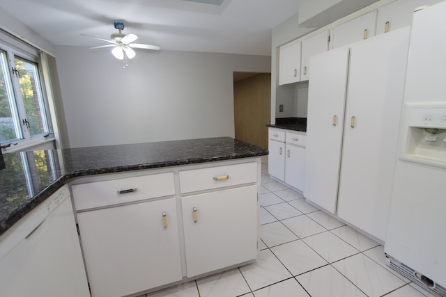 kitchen featuring light tile patterned floors, white cabinets, a ceiling fan, dishwasher, and dark stone counters