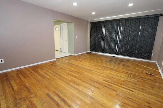 unfurnished room featuring recessed lighting, baseboards, and light wood finished floors