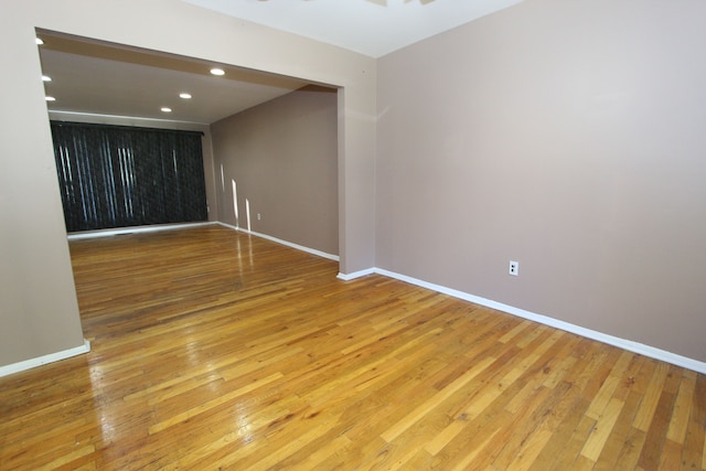 spare room featuring baseboards, recessed lighting, and light wood-style floors