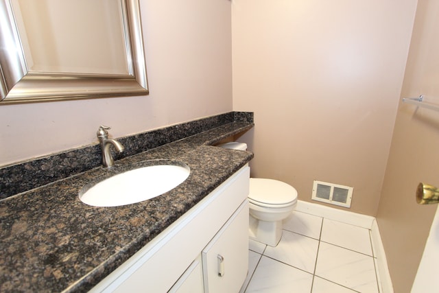 half bath with toilet, tile patterned floors, visible vents, and vanity