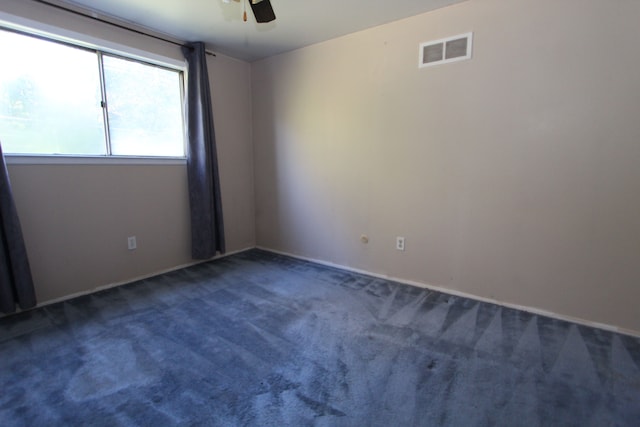 carpeted empty room featuring ceiling fan and visible vents