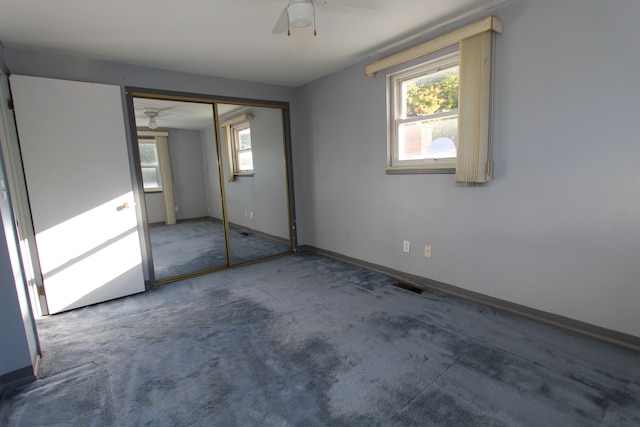 unfurnished bedroom with carpet floors, visible vents, multiple windows, and baseboards