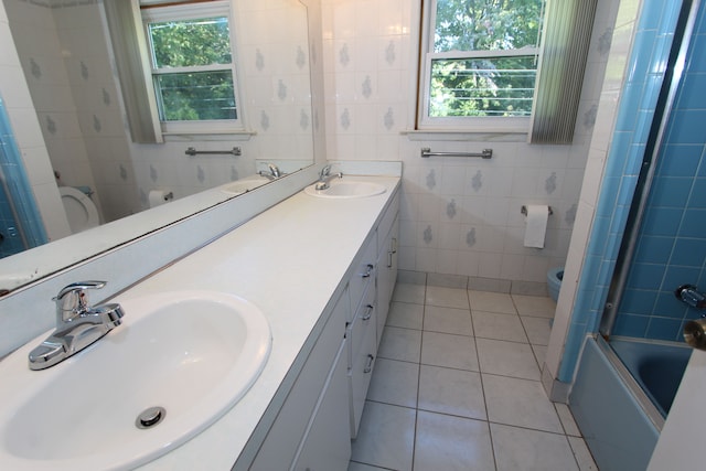 full bathroom with a healthy amount of sunlight, a sink, tile walls, and toilet