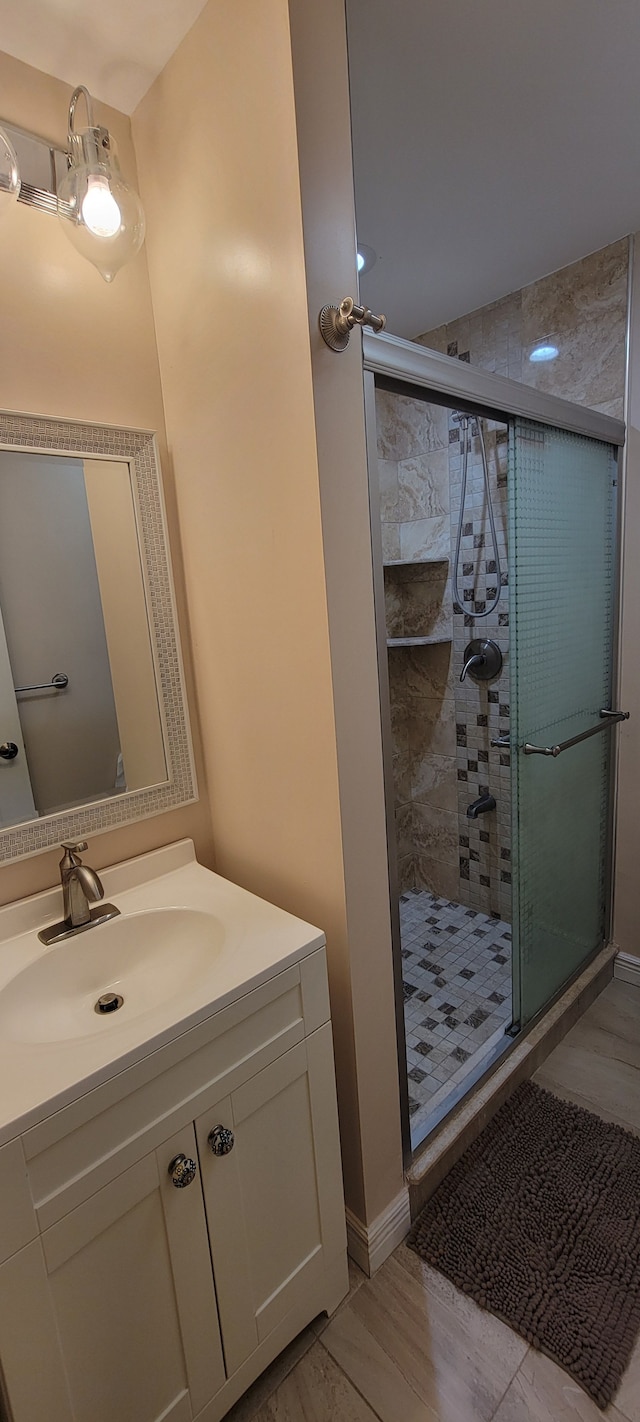 bathroom with a shower stall and vanity