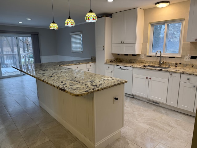 kitchen with decorative backsplash, a peninsula, white dishwasher, white cabinetry, and a sink