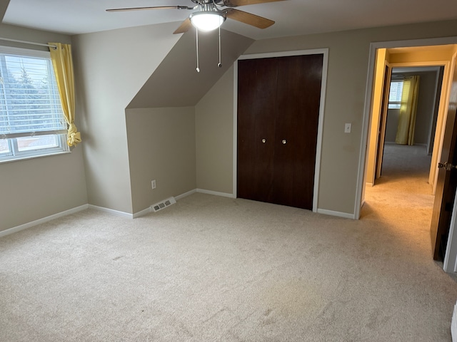 bonus room featuring light carpet, baseboards, visible vents, and a wealth of natural light