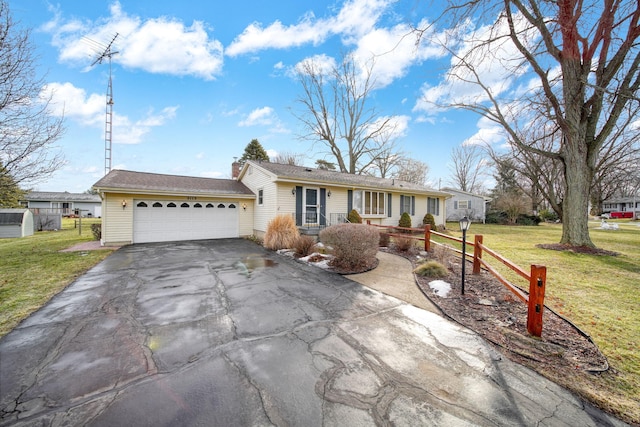 single story home with aphalt driveway, a garage, and a front lawn