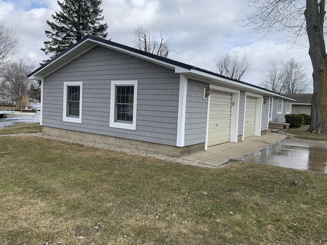 view of side of home featuring a detached garage and a lawn