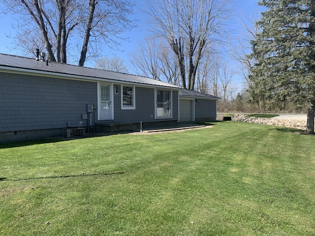 exterior space featuring a lawn and metal roof