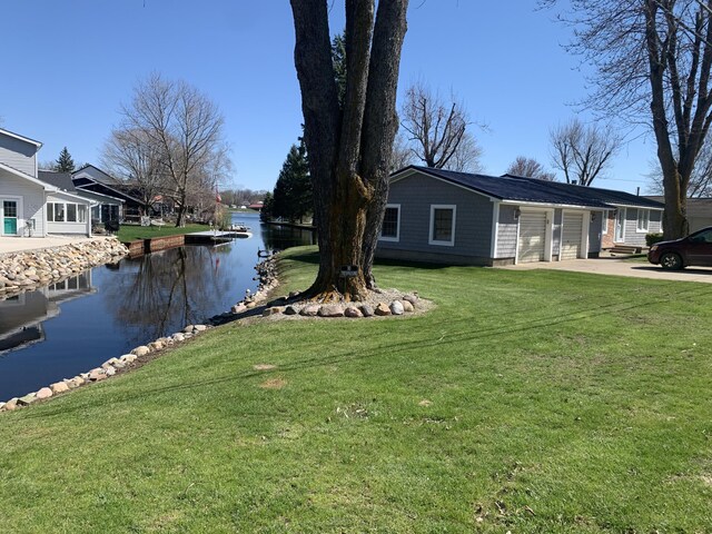 exterior space featuring a garage, driveway, and a water view