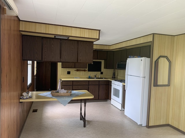 7004 Walnut Hill Rd, Manitou Beach, MI 49253 - kitchen with white appliances, light flooring, wallpapered walls, light countertops, and wood walls