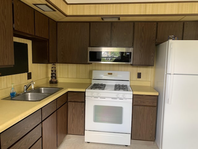 7004 Walnut Hill Rd, Manitou Beach, MI 49253 - kitchen featuring white appliances, a sink, and light countertops