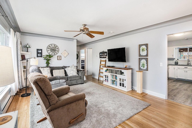 living room featuring light wood-style floors, ceiling fan, and baseboards