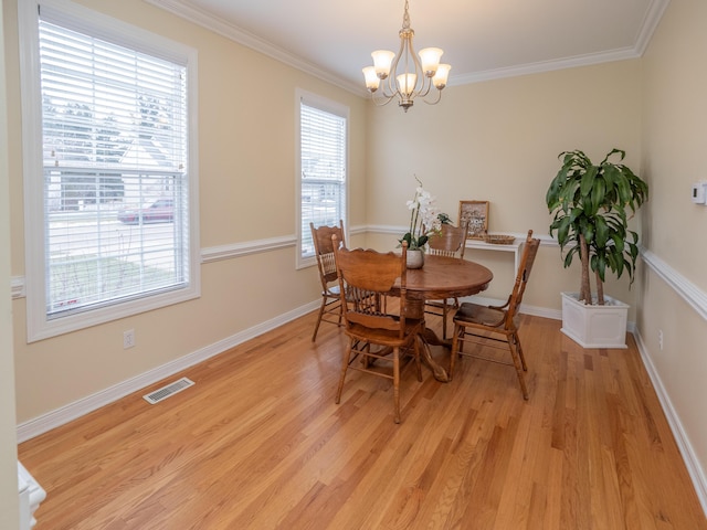 dining space with a notable chandelier, visible vents, baseboards, ornamental molding, and light wood-type flooring