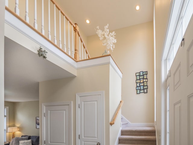 entryway with recessed lighting, baseboards, stairway, and a high ceiling