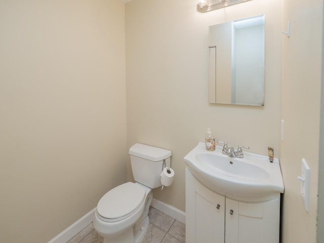 bathroom with baseboards, vanity, and toilet