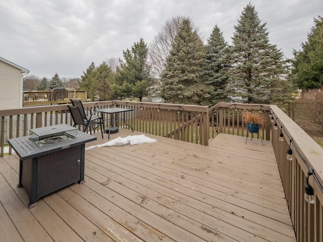 wooden deck featuring an outdoor fire pit